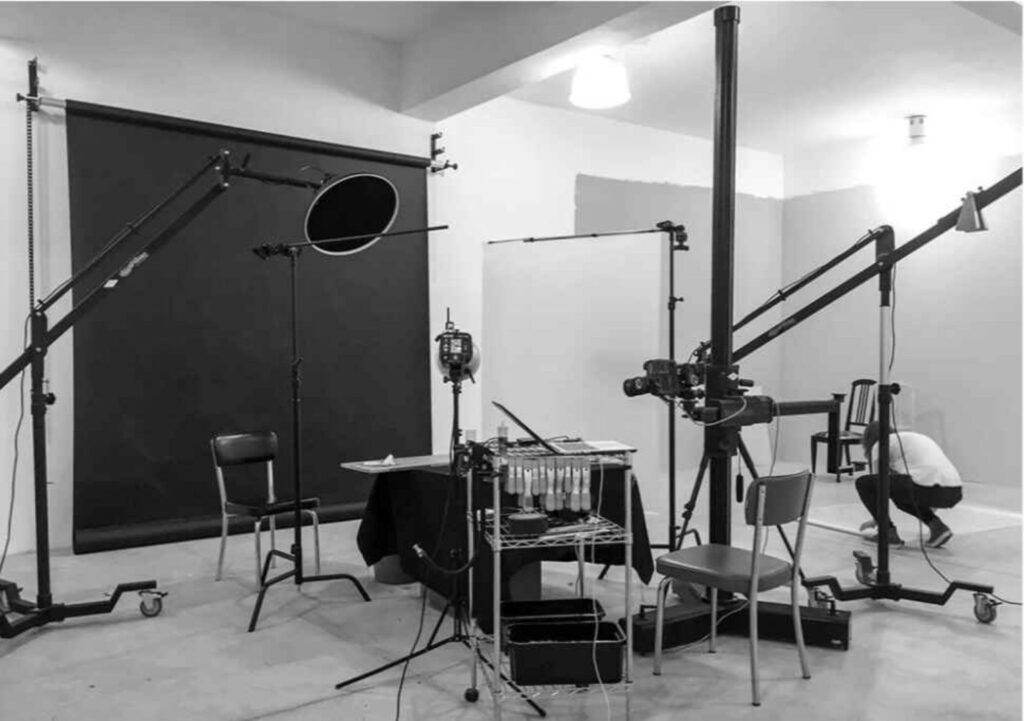 "Professional product photography studio setup with camera, lights, and backdrop"