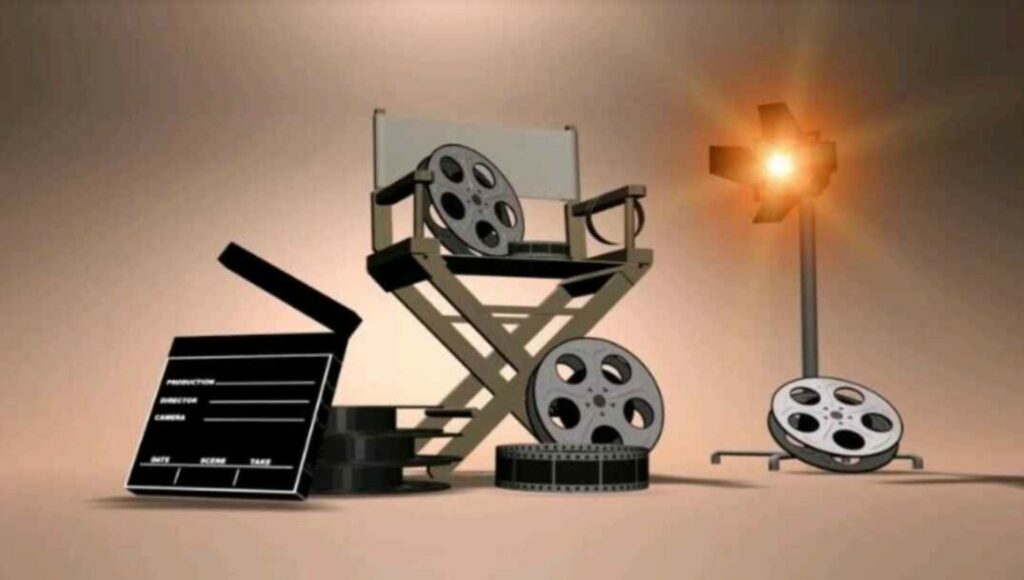 Film pre-production setup showing director’s chair, film reels, clapperboard, and studio light used in filmmaking.