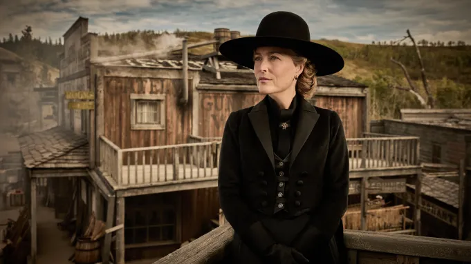 Gillian Anderson stars as the wealthy matriarch Constance Van Ness, standing on a western town balcony in period costume for The Abandons Netflix series.