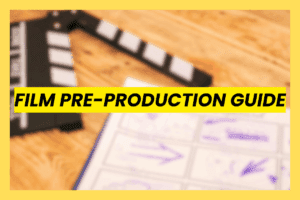 Film Pre-Production Guide header image featuring a blurred film clapperboard and storyboard sketches on a wooden table, symbolizing the pre-production planning workflow for directors and producers.