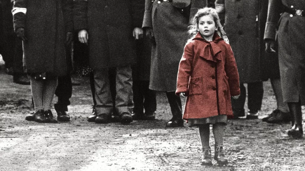 The iconic girl in the red coat walking alone through a black and white crowd in Schindler's List, demonstrating the power of selective color in film.