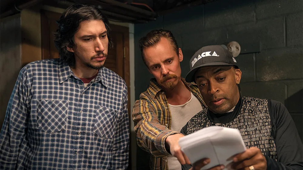 Director Spike Lee reviews a script with actors Adam Driver and Jasper Pääkkö on the set of the movie BlacKkKlansman.
