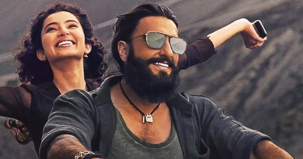 Ranveer Singh riding a motorcycle with a female co-star in a cheerful scene from the movie Dhurandhar.
