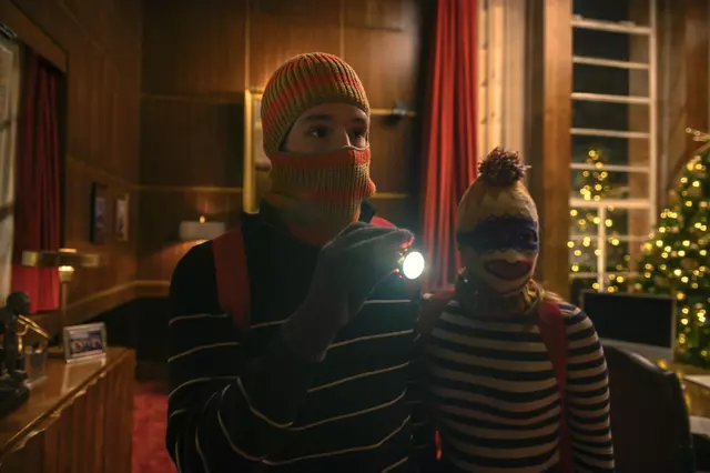 Nick and Sophia wearing ski masks and using flashlights to break into a location during a stealth sequence in Jingle Bell Heist.