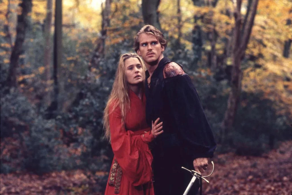 Cary Elwes as Westley and Robin Wright as Buttercup standing close together in a wooded forest setting in a scene from The Princess Bride.