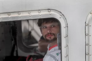 Close-up of Nathan Carman looking through a window, the central figure in The Carman Family Deaths true story on Netflix.