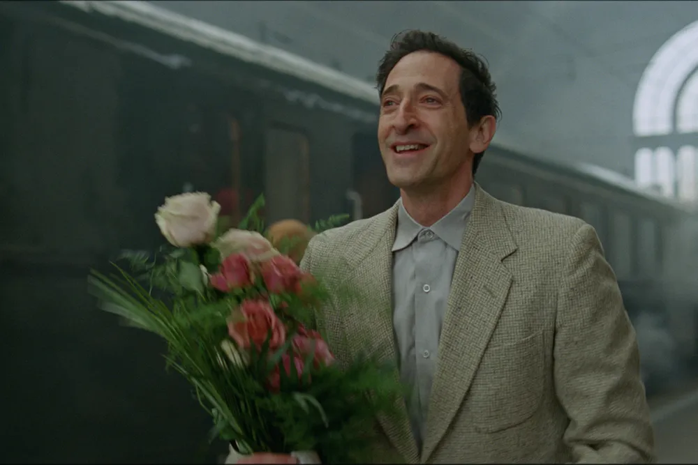 The Brutalist 2024 movie still showing the lead character arriving with flowers – screenplay PDF free download