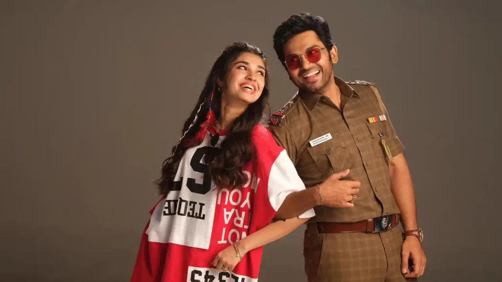 Vaa Vaathiyaar Pongal 2026 movie still showing a cheerful police officer character with a female lead in a playful pose