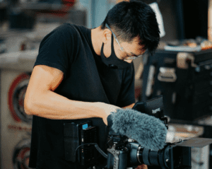 professional filmmaker preparing cinema camera and microphone for movie shooting