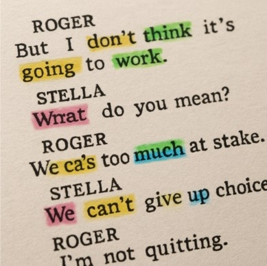 A close-up of a physical script page with different colored highlighter marks on various words.