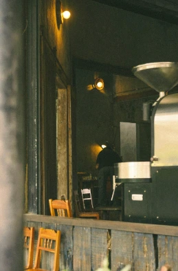 A person shot from the waist up, sitting in a cozy café setting.