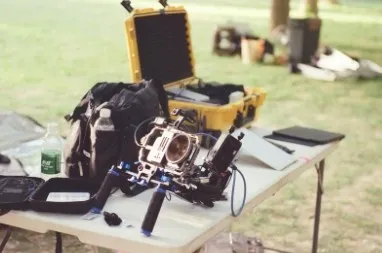 Film crew setting up equipment on location with a director overseeing