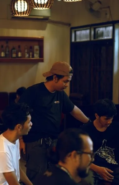 Film crew gathered around a table reviewing the shooting schedule with a director