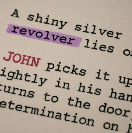Close-up of a script paragraph where 'A shiny silver revolver' is highlighted in purple and 'JOHN' is highlighted in red.