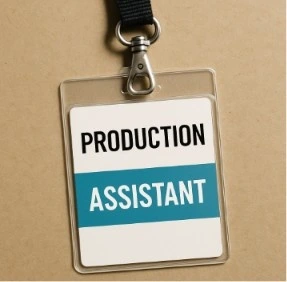 A close-up of a 'Production Assistant' credential badge hanging on a lanyard, symbolizing the start of the career path.