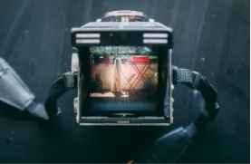 A close-up top view looking into a film camera viewfinder showing a scene being framed on a set.